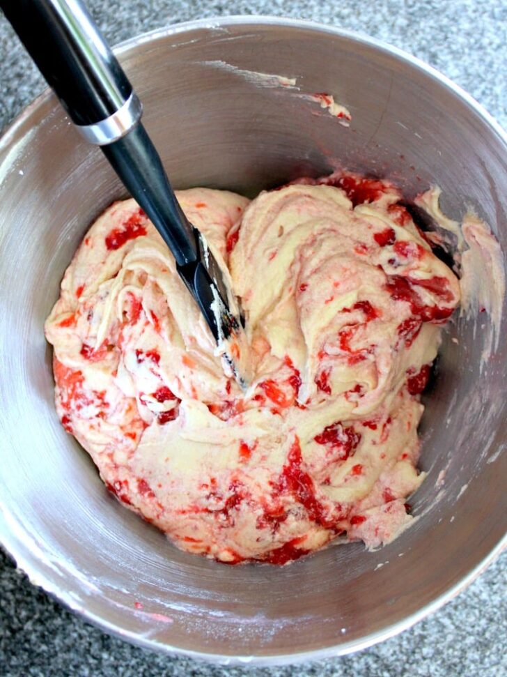 Strawberry Pound Cake showing strawberries added to cake batter Strawberry Pound Cake showing strawberries added to cake batter