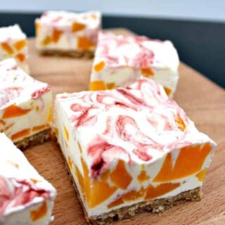 Easy Peach Cheesecake With Raspberry Swirl, a delicious no-bake creamy dessert bursting with juicy peaches. Quick and easy to make and great for parties too!